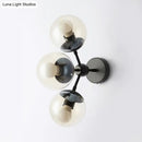 Modern black metal bathroom sconce with three clear glass spheres