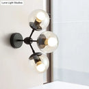 Modern black metal bathroom sconce with three clear glass spheres