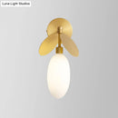 Modern brass leaf wall lamp with cream glass bedroom sconce