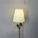 Modern brass led wall sconce with white fabric shade for bedroom