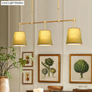 Modern brass pendant light with white green flaxen shades dining room