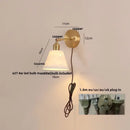 Modern brass wall lamp with frosted glass shade for bedroom reading