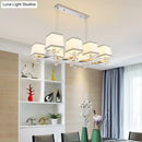 Modern chrome island pendant light with cream shades for dining rooms
