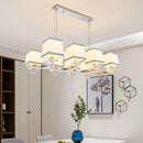 Modern chrome island pendant light with cream shades for dining rooms