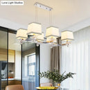Modern chrome island pendant light with cream shades for dining rooms