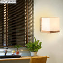 Modern cube shaped sconce wall lamp with wooden backplate bedroom light