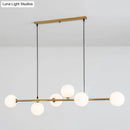 Modern gold metal island pendant with blue glass spheres dining room