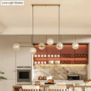 Modern gold metal island pendant with blue glass spheres dining room
