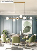 Modern gold metal island pendant with blue glass spheres dining room