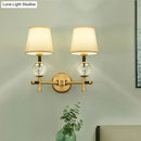 Modern gold wall light with crystal and fabric shade bedroom