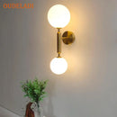 Modern golden led wall sconce with milky glass globes for bedroom