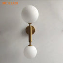 Modern golden led wall sconce with milky glass globes for bedroom