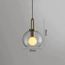 Modern gray glass ball pendant lights – dining room brass accents
