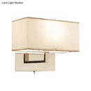 Modern white fabric wall sconce with polished brass for bedroom