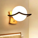 Modern white glass ball sconce with black accent for bedroom