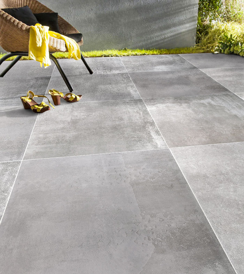Nexos gray porcelain outdoor pavers 2cm thick installed outdoors patio yellow shoes wide view