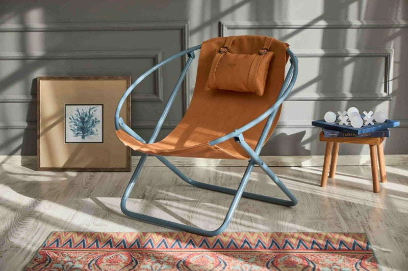 orange foldable metal frame faux leather chair product shot wooden floors wooden side table and picture frame