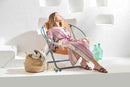 orange foldable metal frame faux leather chair product shot sunbathing woman sitting on towels bottles and towel basket on both sides 