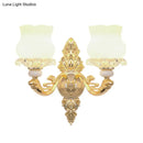 Ornate gold wall light with glass bloom shades – living room fixture