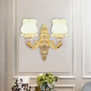 Ornate gold wall light with glass bloom shades – living room fixture