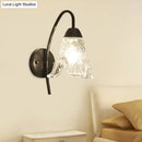 Post-modern black metal wall sconce with clear crystal shade bedroom