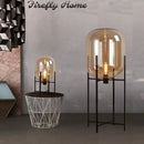 Postmodern amber glass ball floor lamp – living room black metal frame