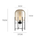 Postmodern amber glass ball floor lamp – living room black metal frame