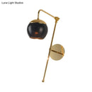 Postmodern black & gold swing arm wall sconce with clear glass bedroom light