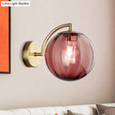 Postmodern brass armed ball sconce – bedroom amber glass wall light