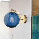 Postmodern brass armed ball sconce – bedroom amber glass wall light