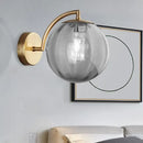 Postmodern brass armed ball sconce – bedroom amber glass wall light