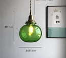 Teal blue glass pendant light with brass hardware for dining room