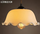 Teal blue glass pendant light with brass hardware for dining room