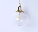 Teal blue glass pendant light with brass hardware for dining room