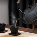 Textured black cast iron tea pot with infuser kitchen steeper