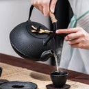 Textured black cast iron tea pot with infuser kitchen steeper