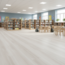 Library with bookshelves and tables on a light wood floor
