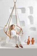 twill natural hanging round chair teak frame blonde woman sitting 3 orange vases