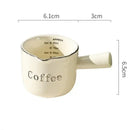 White ceramic espresso measuring cup and milk pitcher kitchen decor