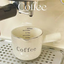 White ceramic espresso measuring cup and milk pitcher kitchen decor