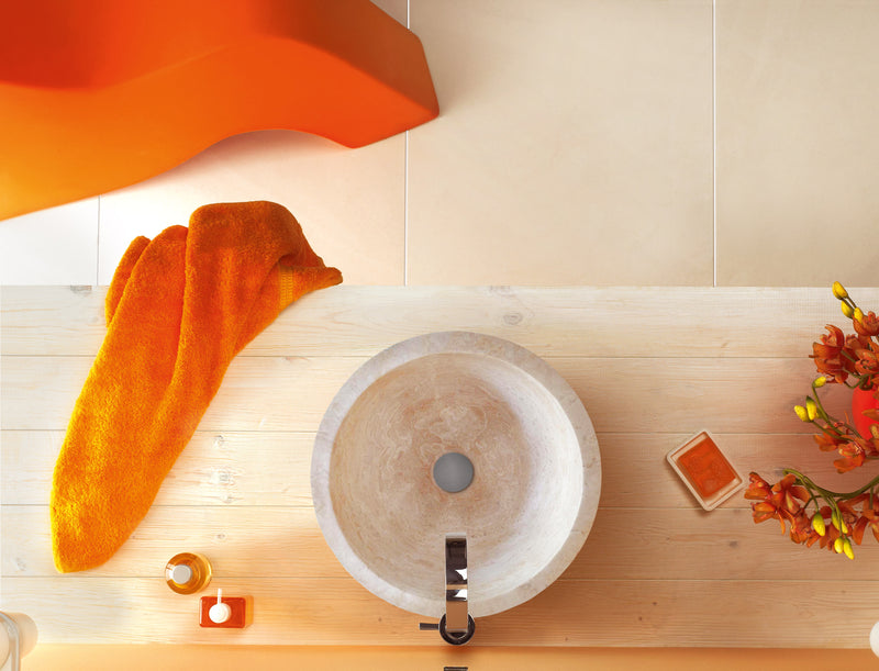 Troia Light Travertine Natural Stone Round Above Vanity Bathroom Sink (D)12.5" (H)6" installed bathroom orange seat and orange towel with orange flower with orange soap one the wooden vanity