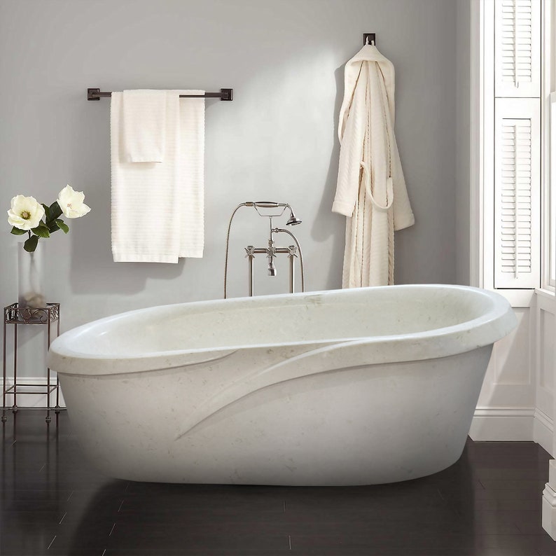 Shell Stone White Limestone Designer Bathtub Hand-carved from Solid Marble Block (W)40" (L)80" (H)24" installed bathroom bathrobe and white towels Hunf on gray tone all white roses on the side table inside glass vase white windows and blind on the right side