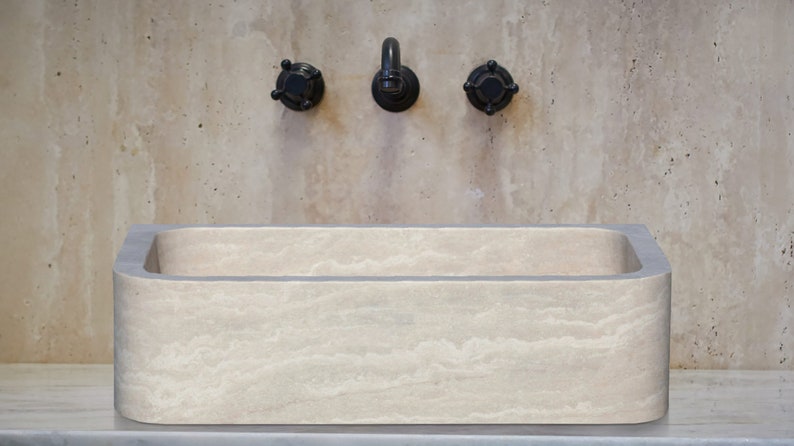 Troia Light Travertine Rectangular Farmhouse Kitchen Sink Honed and Filled (W)18" (L)27.5" (H)7" installed bathroom above stone vanity and travertine wall tiles with black wall-mount faucet