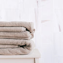 bianco dolomite marble tile 3x6 honed installed to bathroom wall with brown towels closeup