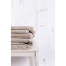 bianco dolomite marble tile 3x6 honed installed to bathroom wall with brown towels