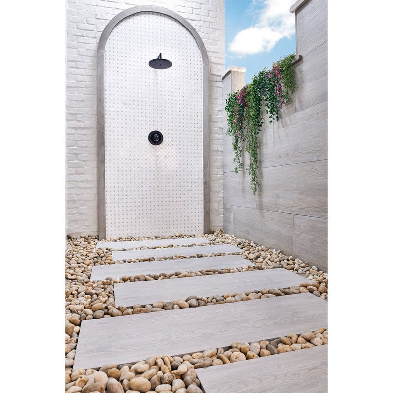 caldera-grigia-porcelain-pavers-16x47in-matte-floor-tile-LPAVNCALGRI1647-installed-to-outside-shower-floor-between-pebbles