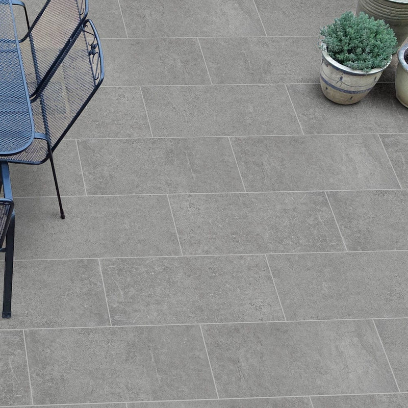 concerto grigio porcelain pavers 18x36in matte floor tile LPAVNCONGRI1836 installed on a nice round patio with iron wrought table and 6 chairs closeup