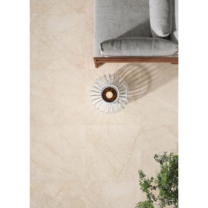living style cream porcelain pavers 24x24in matte floor tile LPAVNLIVCRE2424 installed on living room floor grey couch with coffee table and plant