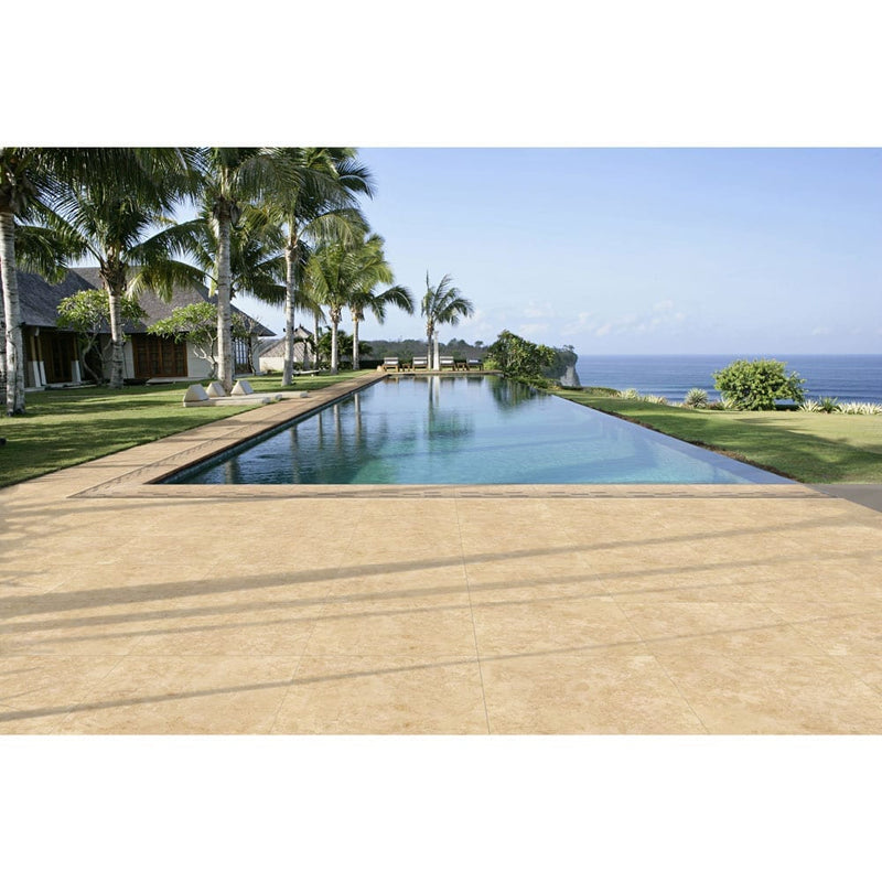 petra beige porcelain pavers 24x24in matte floor tile LPAVNPETBEI2424 installed around swimming pool with a beautiful ocean view